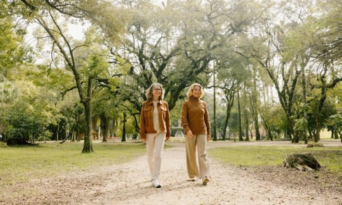 Two women walking on a path in a park