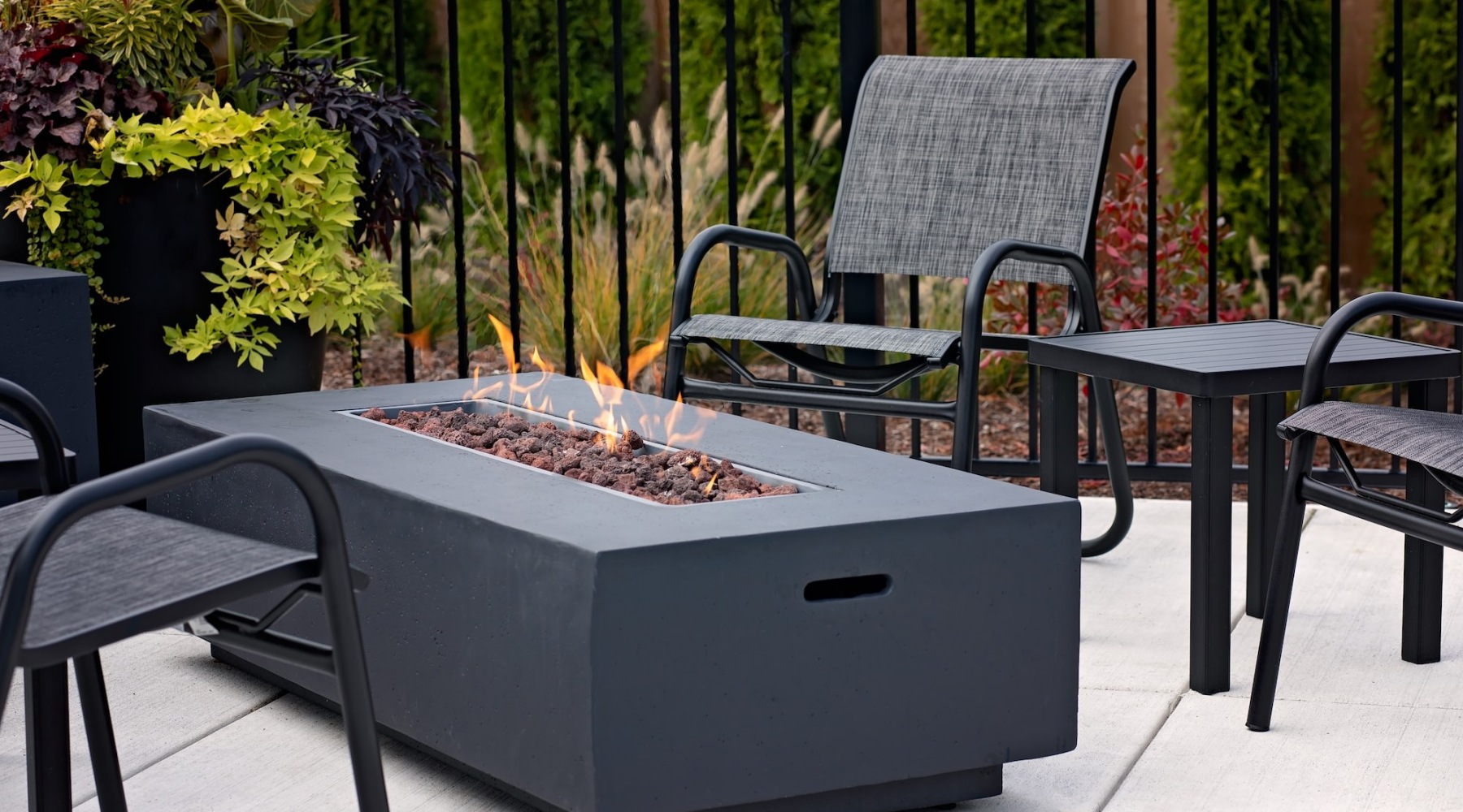 a table with a fire pit on it with chairs around it